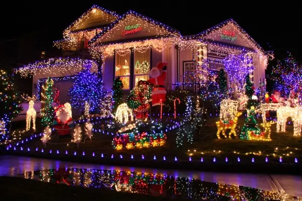 Residential home covered with holiday lighting and seasonal Christmas display.