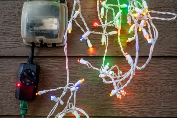 Holiday light hanging by an outdoor GCFI outlet with timer attached. 