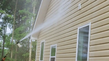 Pressure washing exterior of home.
