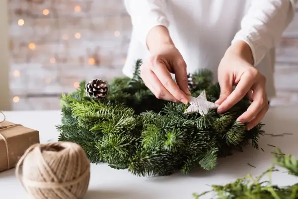 Woman decorating a Christmas wreath.
