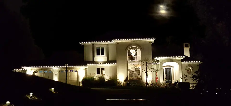 House at night with lights along roofline
